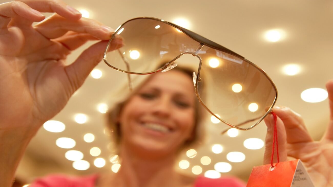 Luxury sunglasses and handbag in warm boutique lighting